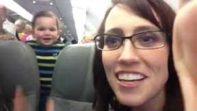 Passenger entertains baby on plane by making him laugh. So cute!