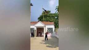 Acrobat climbs up 6-metre-long bamboo stick being held aloft by friend