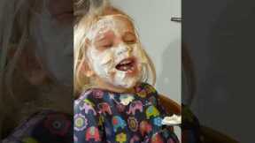 Two-year-old can't contain her laughter as dad paints her face in yoghurt