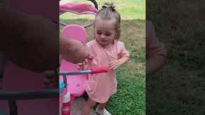 Toddler gets off her bike to greet and kiss a baby snake