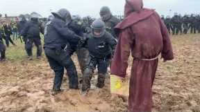 Man dressed as wizard confronts riot police stuck in the mud