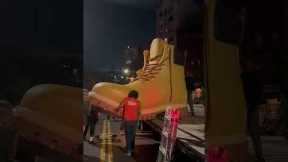 Group of men lift giant Timberland boot