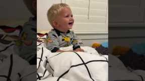 Boy can't control laughter at dad's bed time game