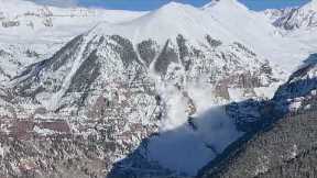 Huge quantities of snow cascade down a mountain in Telluride, Colorado