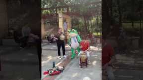 Mascot Frog Dances With Elderly Folk Band